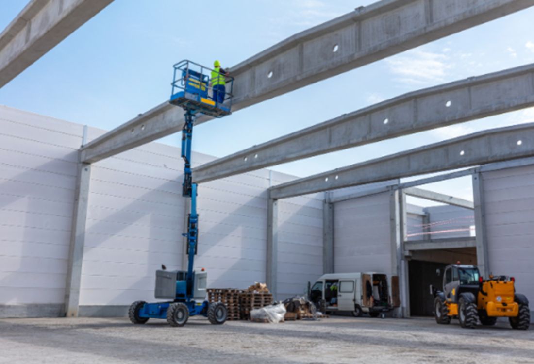 A worker operating a Mobile Elevated Work Platform (MEWP) at a construction site, highlighting the importance of having powered equipment training for site safety. 